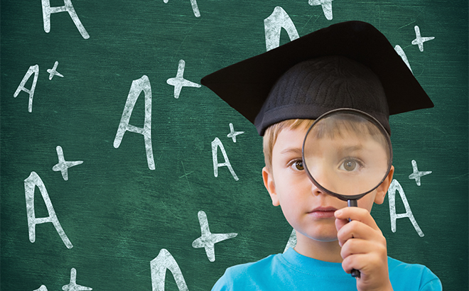 A Child Holding a Magnifiying Mirror with a School Board and Grade A Written on It