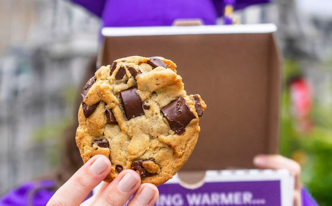 A Graduate Holding a Classic Cookie from Insomnia Cookies