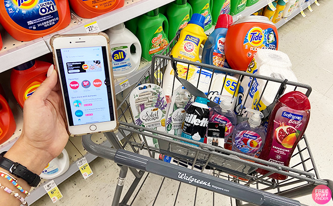 A Hand Holding a Phone in Front of a Walgreens Shopping Cart