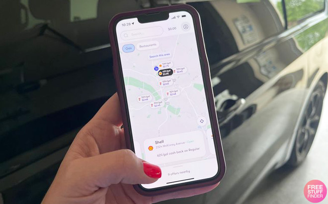 A Person in Front of a Car Holding a Phone and Checking Upside App
