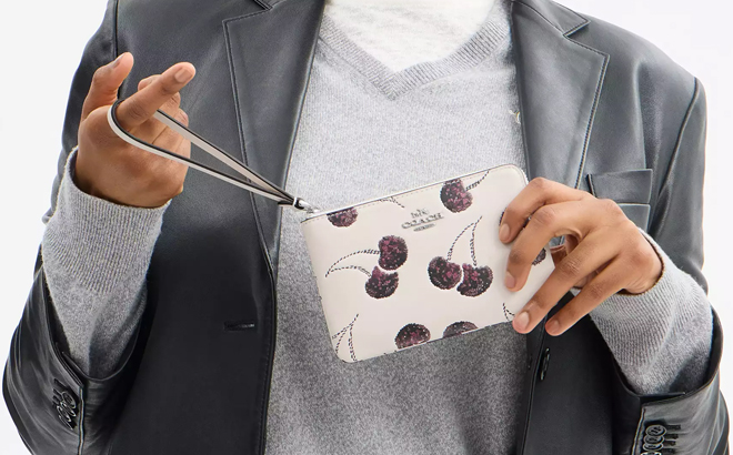 Person Holding Coach Wristlet with Cherry Design